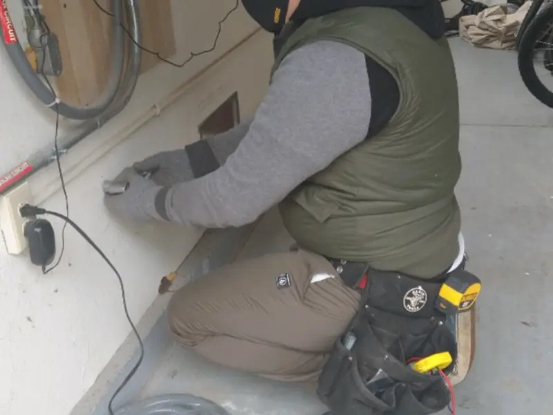 Electrician performing outlet wiring in a Highland Acres garage
